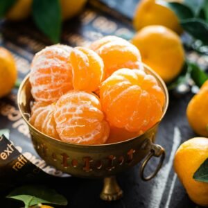 Vibrant peeled and whole tangerines in a rustic bowl highlighting freshness and health.